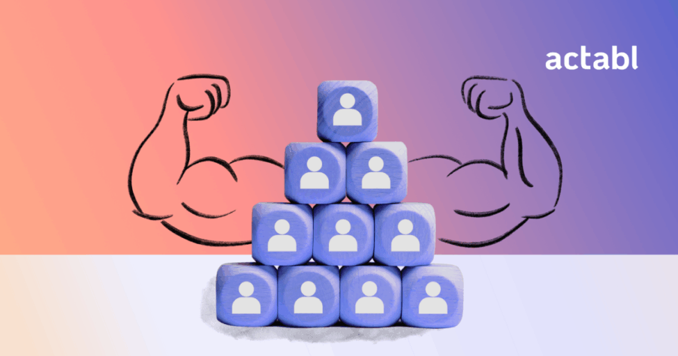 A pyramid of blue blocks with people icons is shown. Behind the pyramid are illustrated muscular arms flexing. The word actabl appears in the top right corner on a gradient background.